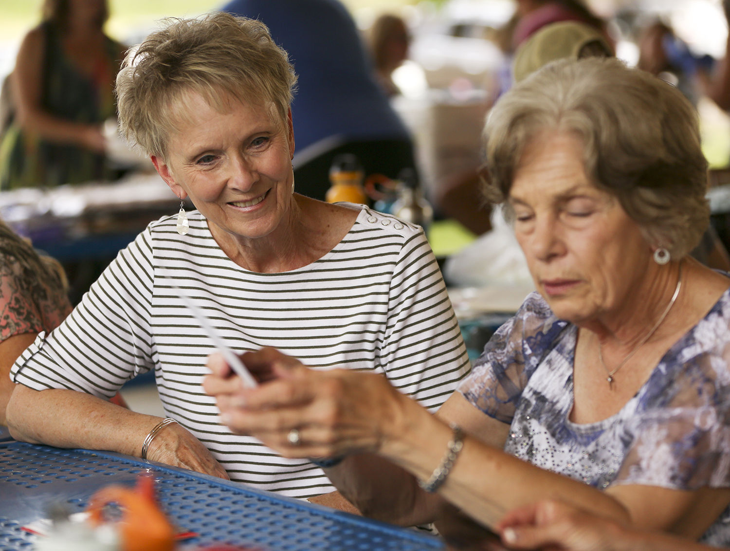 Carolyn Moon, left, and Dee McMahan look through old photographs